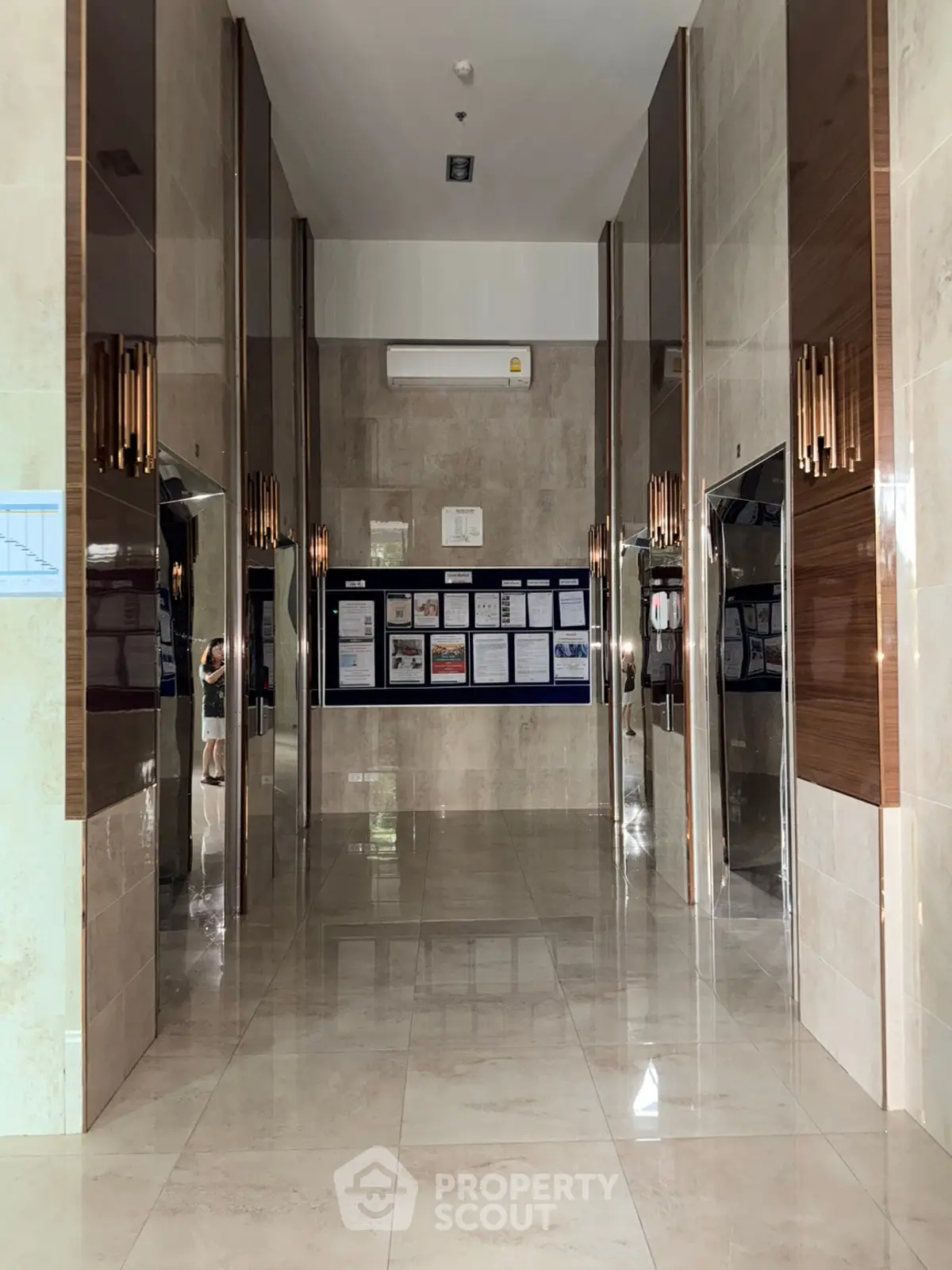 Elegant building lobby with modern elevators and polished marble flooring.