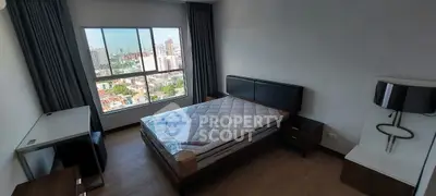 Spacious bedroom with city view, modern furnishings, and ample natural light in a high-rise apartment.