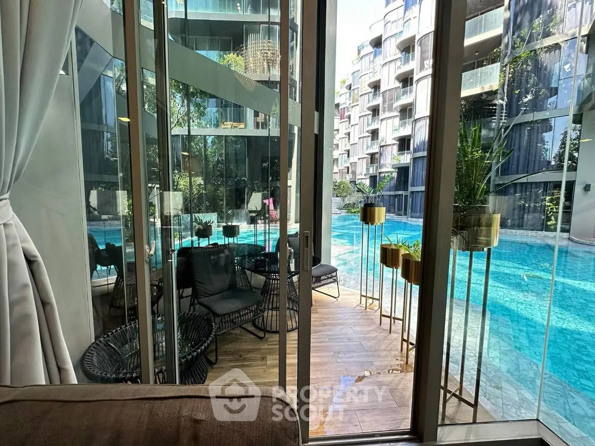 Luxurious condo with pool view and modern glass facade, perfect for urban living.