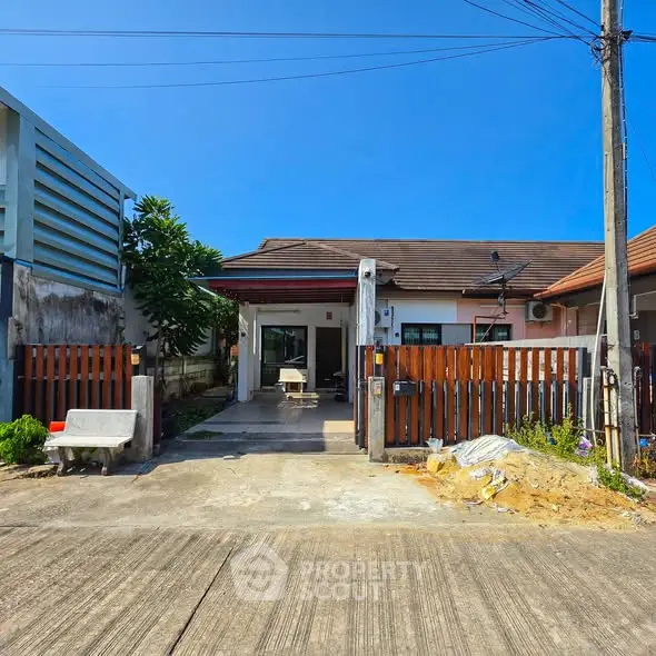 Charming single-story home with gated entrance and driveway in a serene neighborhood.