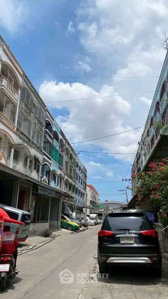 Charming urban street view with residential buildings under a bright blue sky.