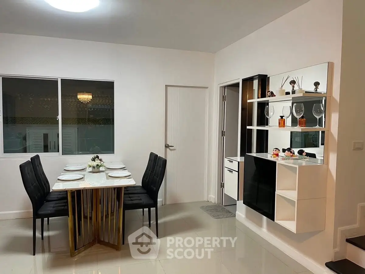 Modern dining area with elegant table and stylish shelving in a contemporary home.