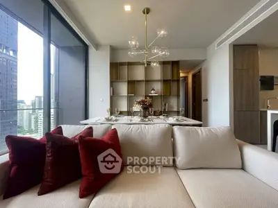 Luxurious modern living room with elegant decor and city view, featuring plush sofa and stylish chandelier.