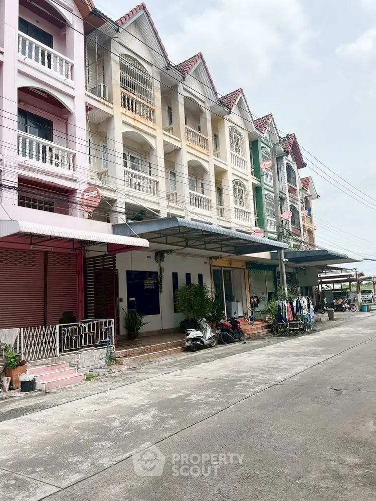 Charming row of colorful townhouses with unique architectural design and ample parking space.