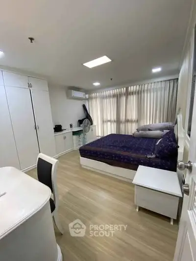 Spacious bedroom with modern furnishings and natural light