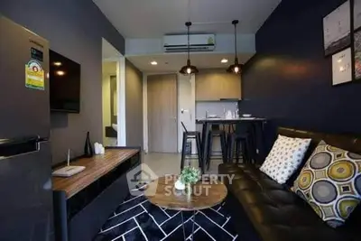 Modern living room with stylish decor and open kitchen layout in a cozy apartment.