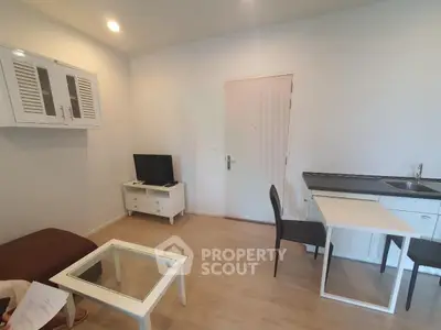 Modern living room with minimalist furniture and integrated kitchenette in cozy apartment.