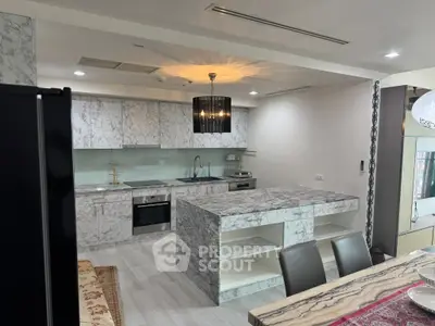 Luxurious modern kitchen with marble countertops and sleek appliances in open layout design.