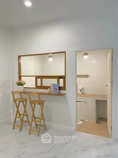 Charming kitchen with breakfast bar and stools, featuring modern design and cozy ambiance.