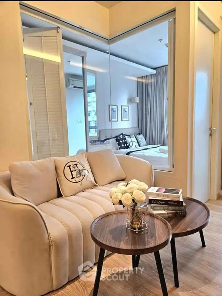 Modern living room with cozy sofa and view into stylish bedroom