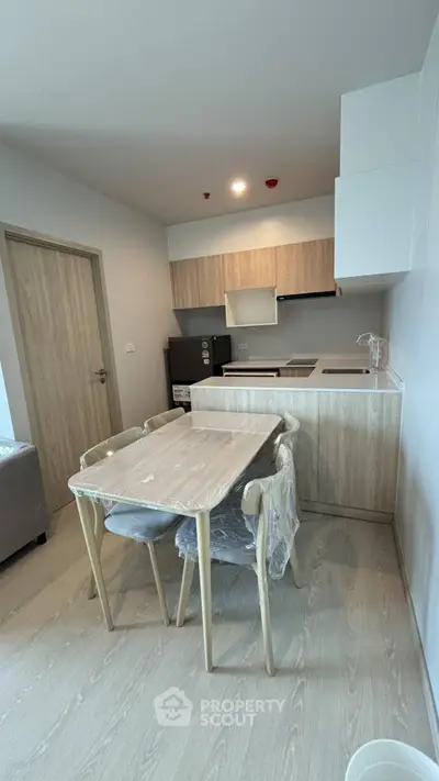 Modern kitchen with sleek cabinetry and dining area in stylish apartment