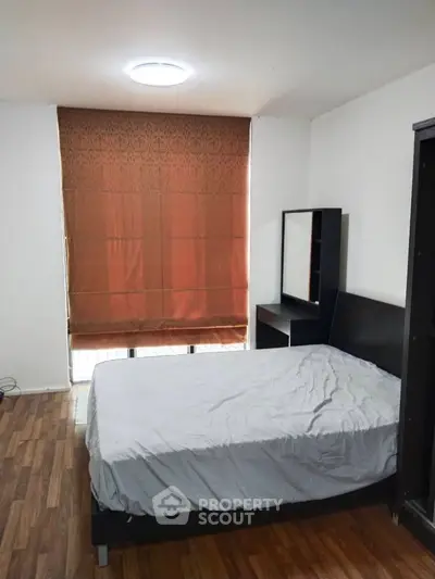 Cozy bedroom with wooden flooring and modern furniture