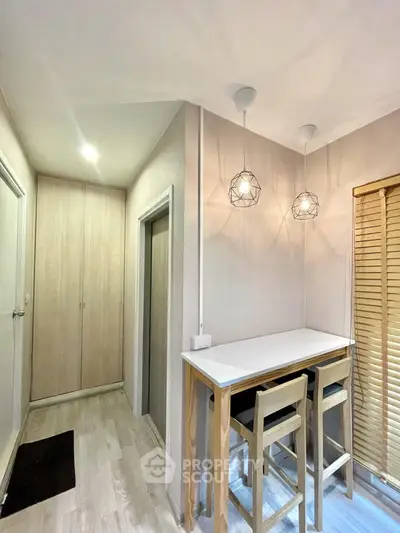 Modern kitchen with stylish lighting and wooden accents in a cozy apartment.