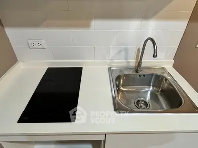 Modern kitchen with sleek induction cooktop and stainless steel sink, perfect for contemporary living.
