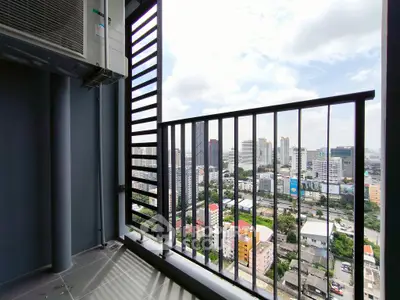 Stunning cityscape view from a high-rise balcony with modern railing and air conditioning unit.