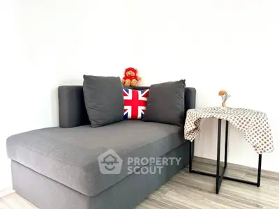 Cozy living room with modern gray sofa and stylish side table, perfect for relaxation.