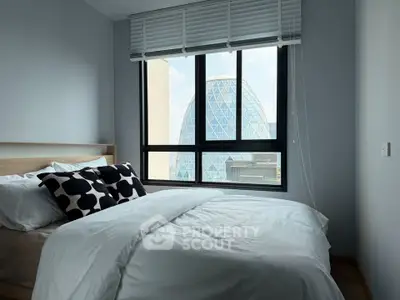 Modern bedroom with city view featuring stylish decor and large window.