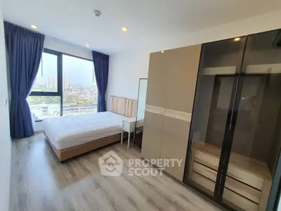 Modern bedroom with large window and stylish wardrobe in a high-rise apartment.