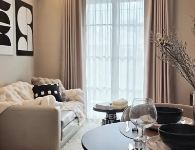 Elegant living room with cozy sofa, modern decor, and large window for natural light.