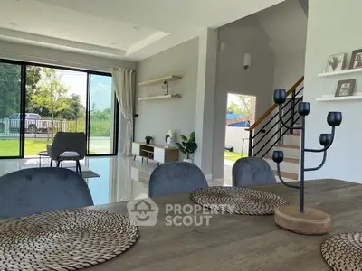 Spacious modern living room with open layout and garden view, perfect for family gatherings.