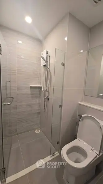 Modern bathroom with sleek shower and toilet in contemporary design.