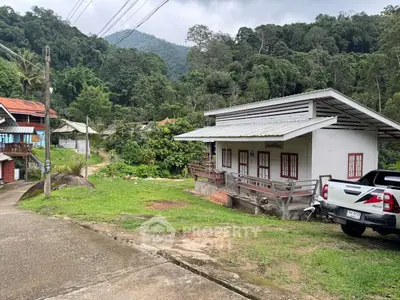 Charming rural house with lush greenery and mountain backdrop, ideal for nature lovers seeking tranquility.