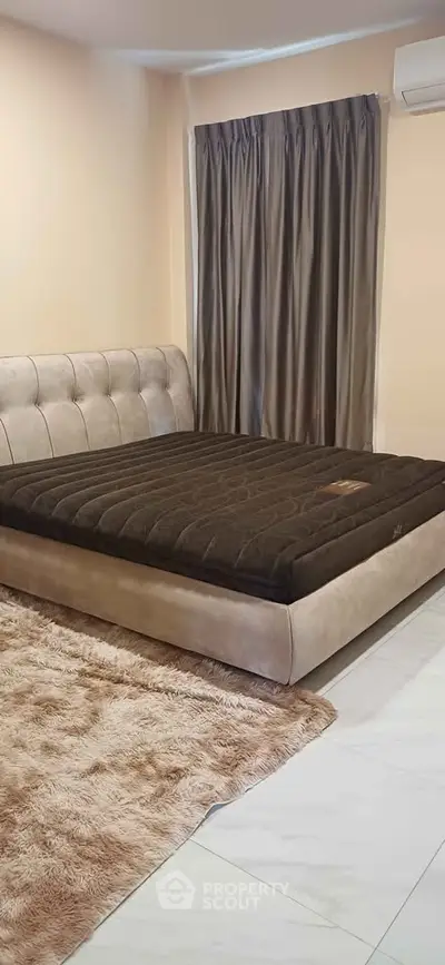 Cozy bedroom with plush bed and elegant curtains, perfect for relaxation.