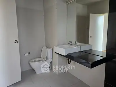 Modern bathroom with sleek fixtures and dual sinks in a contemporary apartment.