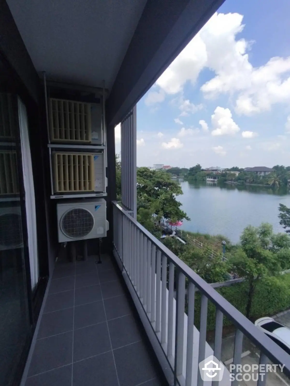 Stunning balcony view overlooking serene lake and lush greenery, perfect for relaxation and enjoying nature.