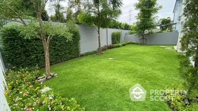 Spacious green garden with lush trees and manicured lawn in a serene residential area.