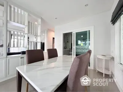 Elegant dining area with marble table and modern decor in a bright, spacious home.