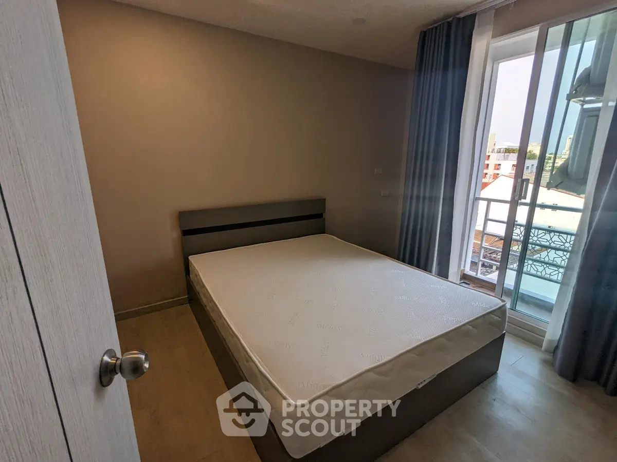 Cozy bedroom with natural light and balcony access in modern apartment