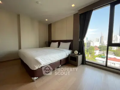 Spacious bedroom with city view and modern decor in urban apartment