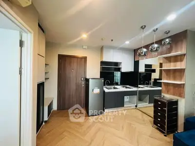 Modern kitchen with sleek design and open layout, featuring stylish lighting and wooden flooring.