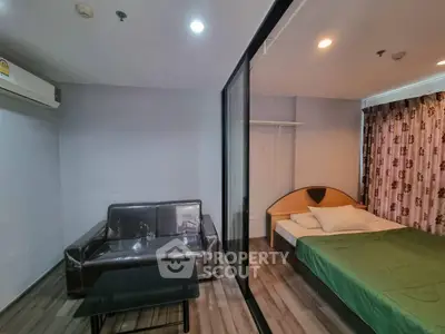Modern studio apartment with glass partition, featuring cozy living area and stylish bedroom.