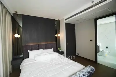 Modern bedroom with elegant decor and ensuite bathroom in luxury apartment.