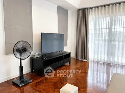 Spacious living room with sleek TV setup and elegant parquet flooring