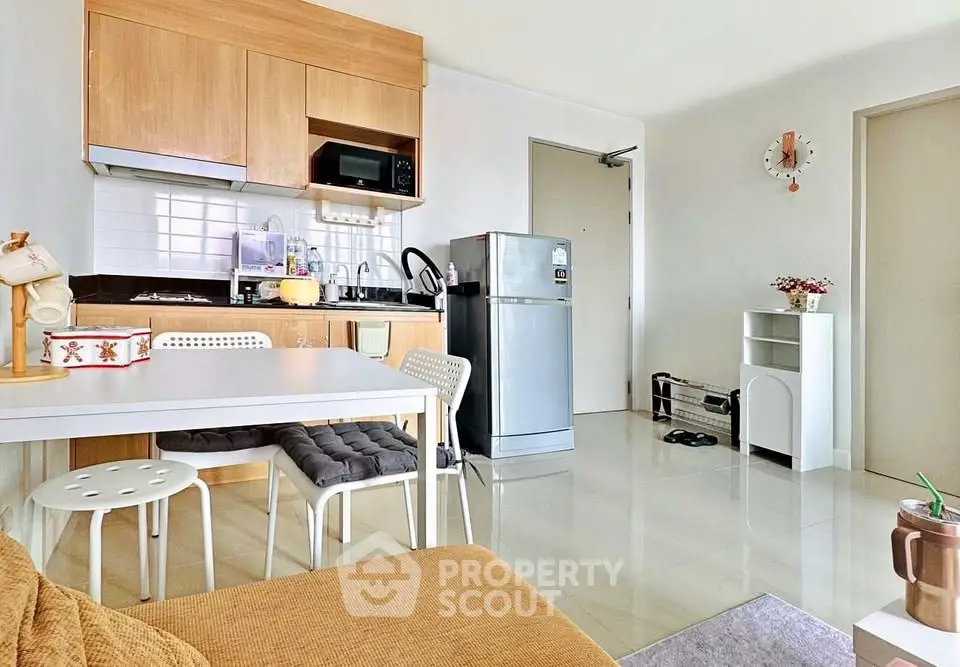 Modern kitchen with sleek appliances and cozy dining area in a bright apartment.