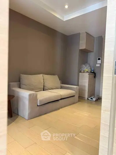 Cozy living room with modern sofa and wooden flooring in a stylish apartment.