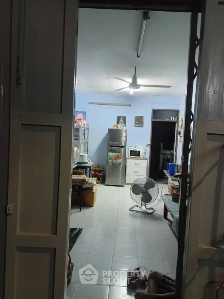 Cozy kitchen with fridge and ceiling fan in a welcoming home interior.