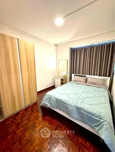 Cozy bedroom with wooden flooring and modern wardrobe
