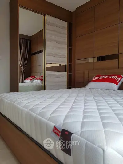 Modern bedroom with stylish wooden paneling and comfortable mattress, perfect for a cozy retreat.
