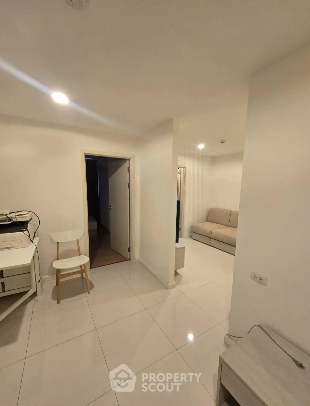 Modern minimalist interior with white tiles and neutral furniture, perfect for urban living.