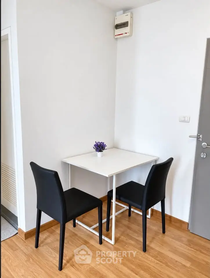 Cozy dining nook with modern table and chairs in a minimalist apartment setting.