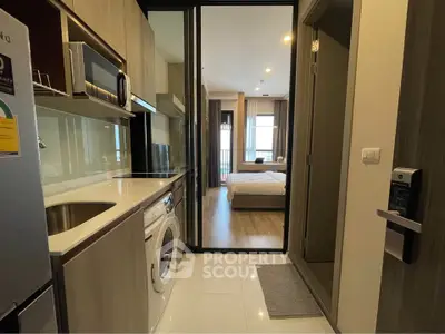 Modern apartment interior with compact kitchen and cozy bedroom view