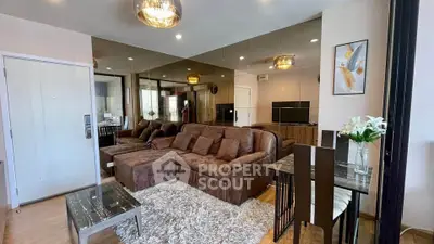 Luxurious living room with plush brown sofa, mirrored wall, and elegant decor in modern apartment.