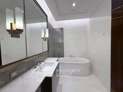 Luxurious modern bathroom with elegant marble finishes and a sleek bathtub.