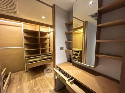 Spacious walk-in closet with wooden shelves and mirror, perfect for organized storage.