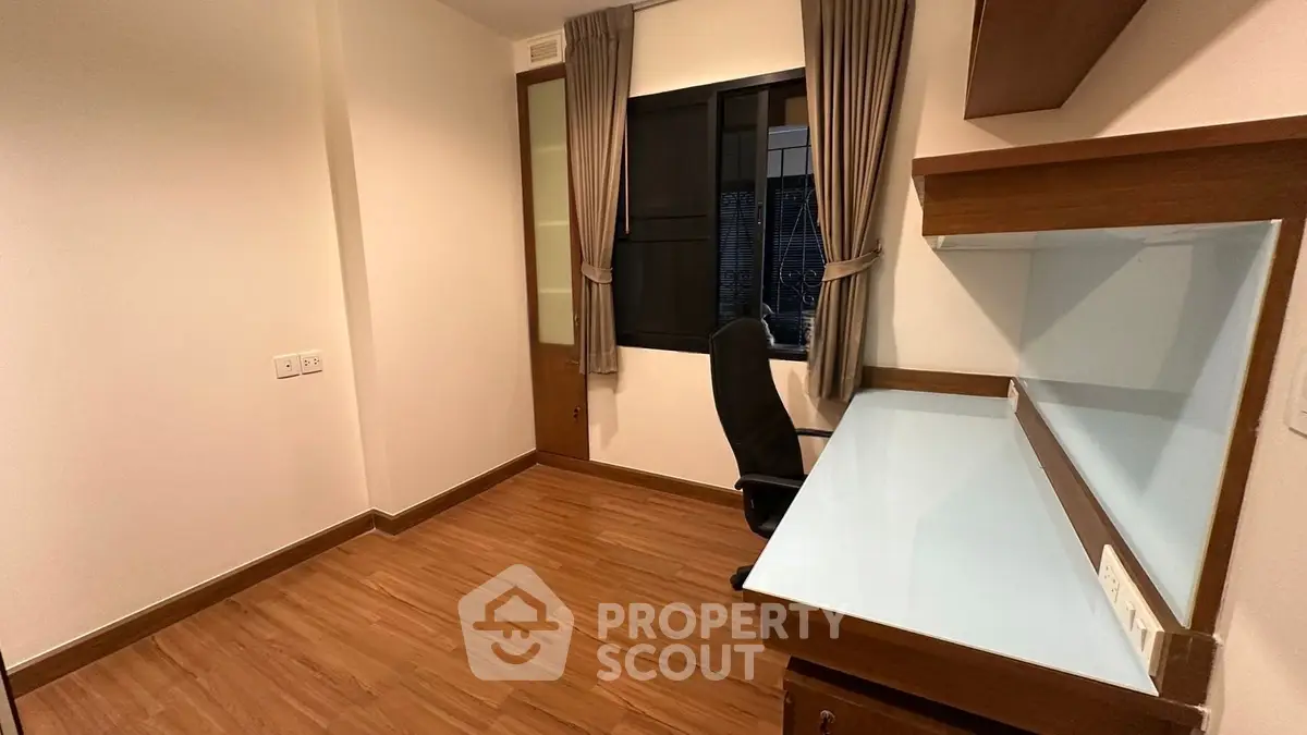 Modern study room with wooden flooring and built-in desk, ideal for productivity.