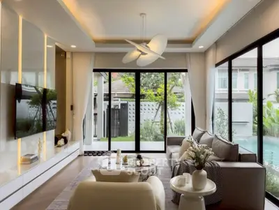Luxurious living room with modern decor and pool view, featuring elegant furniture and large windows.